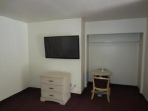 a room with a dresser and a tv on a wall at Tropico Motel in Glendale