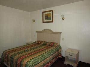 a bedroom with a bed and a picture on the wall at Tropico Motel in Glendale