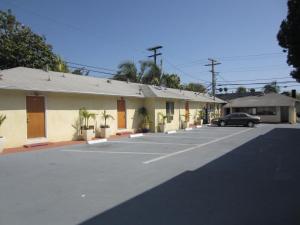 een gebouw met een auto geparkeerd op een parkeerplaats bij Tropico Motel in Glendale