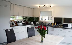 吉斯维尔Haus Melchaazopf的厨房里有一张桌子，桌子上放着一瓶花