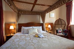 a bedroom with a canopy bed with a tray of food on it at Scholars Townhouse Hotel in Drogheda +26 photos