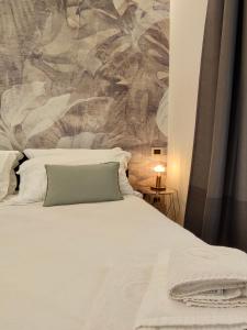 a bed with a white comforter and pillows at Il Meraviglioso Mondo di Amélie in Agrigento