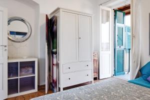 拉斯佩齊亞的住宿－Le Viole Matte - Appartamento immerso nel Verde con Vista Mare，卧室配有白色衣柜和镜子