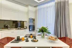 biała kuchnia z białym stołem i krzesłami w obiekcie S&T LUXURY HOUSE in PLEBISCITO SQUARE w mieście Neapol