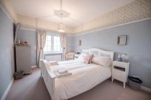 una camera da letto con un grande letto bianco e una finestra di 46 Ivy Cottage, Easton a Woodbridge