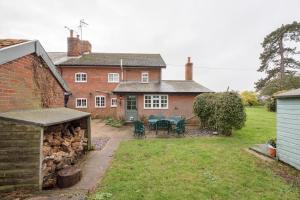 una casa in mattoni con tavolo e sedie in cortile di 46 Ivy Cottage, Easton a Woodbridge