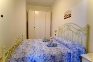 1 dormitorio con 1 cama azul y 2 almohadas en La rosa dei venti, apartment 2, en Porto Empedocle