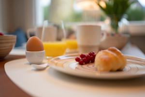 a plate of food with eggs and fruit on a table at Studio-Apartment Piccolino 26 in Timmendorfer Strand
