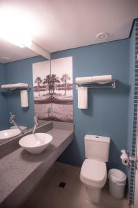 een badkamer met een wit toilet en een wastafel bij Golden Tower Aeroporto - Lizz - by Fênix Hotéis in Uberlândia