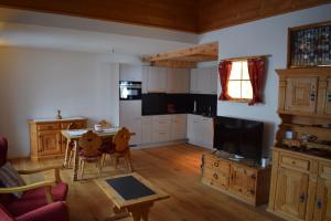 a living room with a table and a kitchen at B&B Stiffler-Huus in Davos