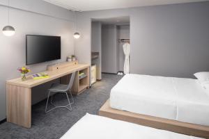 a hotel room with a bed and a desk with a television at Henn na Hotel New York in New York +24 photos