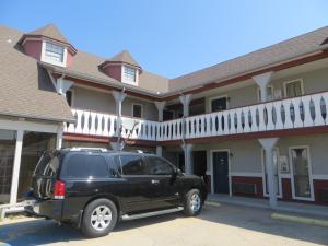 een zwarte SUV geparkeerd voor een gebouw bij Executive Inn Wichita in Wichita