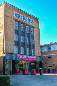 un edificio de ladrillo con un cartel que lee "Crece pizza de piña" en Crowne Plaza Liverpool - John Lennon Airport, an IHG Hotel en Liverpool