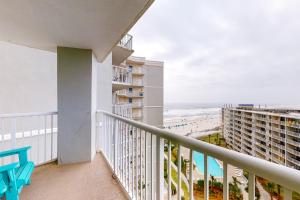 a balcony with a view of the beach and condos at Tradewinds #1008 in Orange Beach