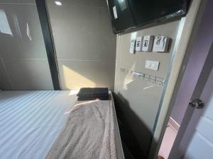 a small room with a bed and a glass door at Charinsup Pinklao Hotel in Bang Kruai