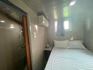 a small room with a bed and a window at Charinsup Pinklao Hotel in Bang Kruai