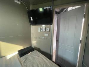 a room with a tv and a bed and a door at Charinsup Pinklao Hotel in Bang Kruai +3 photos