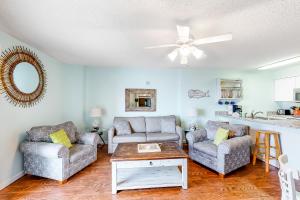 a living room with two chairs and a couch and a ceiling fan at Tradewinds #1008 in Orange Beach