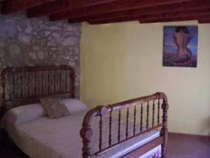 1 dormitorio con 1 cama y una pintura en la pared en Apartamentos Rurales La Fàbrica, en Agost