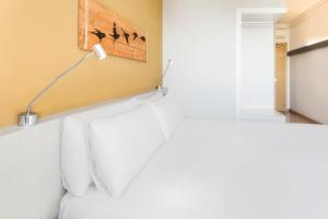 a bedroom with a bed with a lamp on it at B&B HOTEL Barcelona Viladecans in Viladecáns