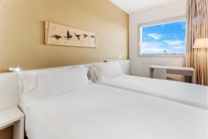 Un pat sau paturi într-o cameră la B&B HOTEL Barcelona Viladecans