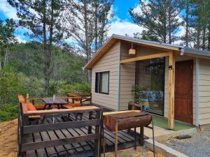 une petite maison avec une table et un grill dans l'établissement Cabaña Refugio Sauna Spa El Arrayan Casablanca Valdivia, à Valdivia