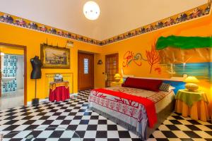 1 dormitorio con 1 cama en una habitación con paredes amarillas en Orchid Corner Guesthouse, en Meta