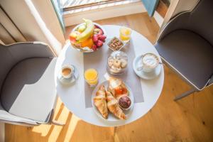 a white table with breakfast foods and drinks on it at Antico Corso Charme in Cagliari