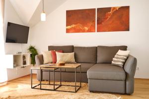 a living room with a couch and a table at die Tauplitz Lodges - Mountain view Lodge A11 by AA Holiday Homes in Tauplitz