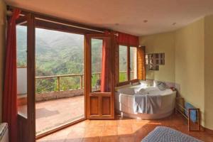 eine Badewanne in einem Zimmer mit Balkon in der Unterkunft El Ablanu Senda del Oso in Proaza