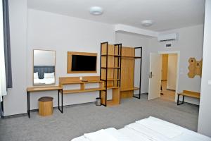 a bedroom with a desk and a computer and a tv at Hotel Ricas in Sliven