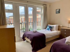 a bedroom with two beds and a large window at Trevelyan Court Apartments Windsor in Windsor +51 photos