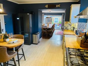 インバネスにあるLairds Lodge Invernessの青い壁のキッチン&ダイニングルーム(テーブル付)