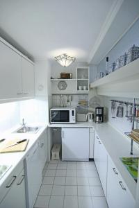 a kitchen with white cabinets and a microwave at Apartment Di Wiis in Westerland (Sylt)