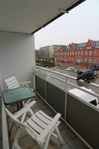 two chairs and a table on a balcony at Apartment Di Wiis in Westerland (Sylt)
