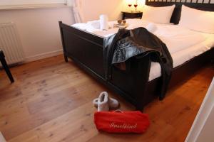 ヴェスターラントにあるFerienwohnung Dünensandの黒いベッド1台、床に動物の詰め物が置かれたベッドルーム1室