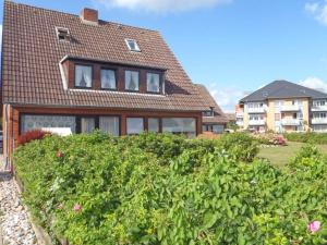 una casa con una grande siepe davanti di Ferienwohnung Kleine Düne a Westerland