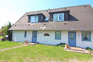 a house with blue doors and a brown roof at Ferienwohnung Seeute Deern in Westerland