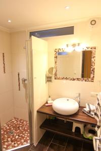 a bathroom with a sink and a mirror at Ferienwohnung Lena Bockelmann´s Hof (ebenerdig) in Westerland (Sylt) +16 photos