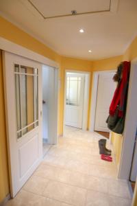 a hallway with yellow walls and a white door at Ferienwohnung Lena Bockelmann´s Hof (ebenerdig) in Westerland (Sylt)