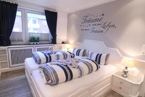 Dormitorio blanco con cama con almohadas en Käpt`n Hörnchen en Hörnum