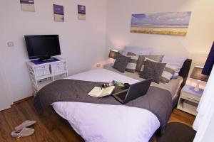 une chambre avec un lit avec un ordinateur portable dessus dans l'établissement Haus Heidi, à Westerland