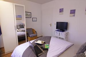 - une chambre avec un ordinateur portable sur un lit et une télévision dans l'établissement Haus Heidi, à Westerland