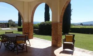 un patio con mesa y sillas en un edificio en Agriturismo Fattoria il Piano - Casa Bugno - San Gimignano, en San Gimignano