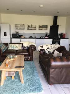 a living room with two leather couches and a coffee table at The Lambing Shed in Dunvegan