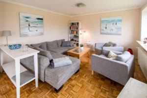ein Wohnzimmer mit einem Sofa und einem Tisch in der Unterkunft Haus Seeblick I in Glücksburg