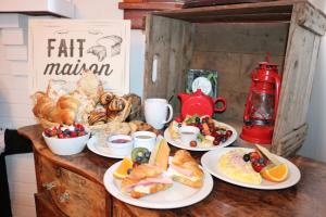 a table topped with plates of food and pastries at Les Petits Trésors in Coaticook
