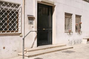 una porta nera su un edificio bianco con scale di Vatican City Accommodation a Roma