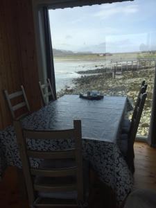 a dining room table with chairs and a view of the beach at Riisebruket in Havningberg