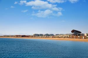 widok na plażę z budynkami i ocean w obiekcie Rixos Premium Magawish Suites and Villas- Ultra All-Inclusive w mieście Hurghada